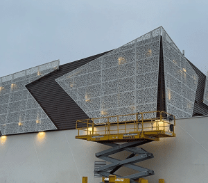 Un bardage métallique fait par un architecte en train d'être posé sur un bâtiment