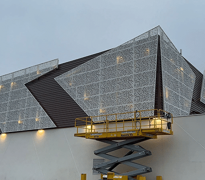 Un bardage métallique fait par un architecte en train d'être posé sur un bâtiment